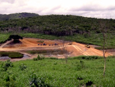 g) Vista panorâmica da construção do maciço de terra da barragem e da “área de empréstimo”.